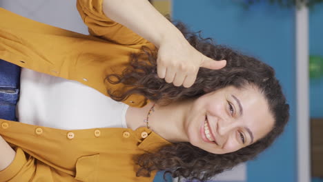 Vertical-video-of-Young-woman-making-positive-gesture-at-camera.